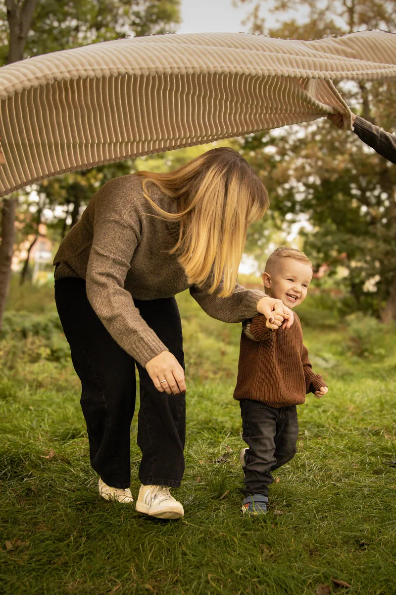 Mama z dwójką dzieci na pikniku na łące, pod słońce